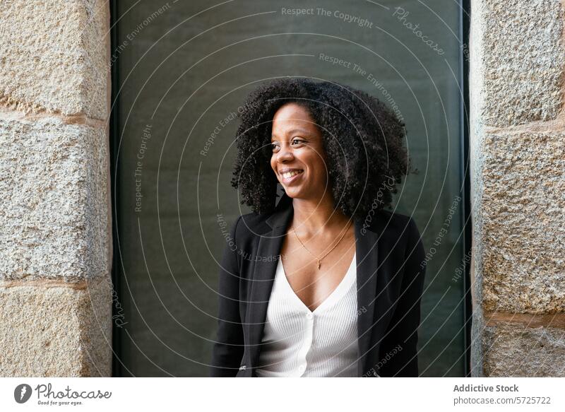 Confident Black businesswoman smiling near office building female black african american professional smile confident curly hair business attire doorway