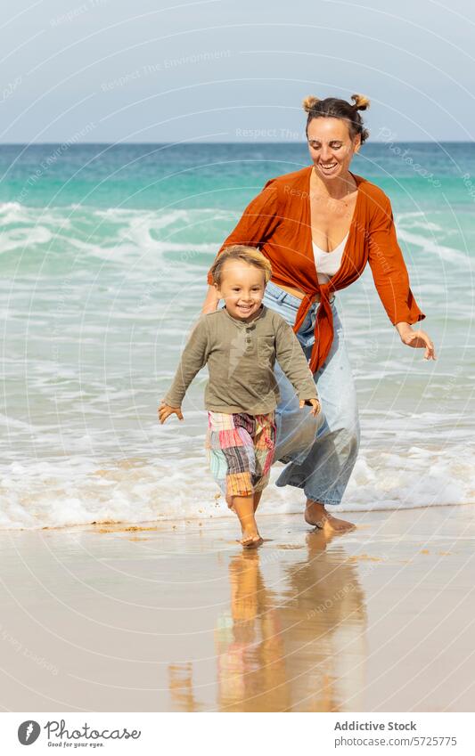 Family Joy on a Sunny Beach Day beach family fun boy child mother ocean play running sand sunny holiday vacation leisure sea happiness joy outdoor water wave