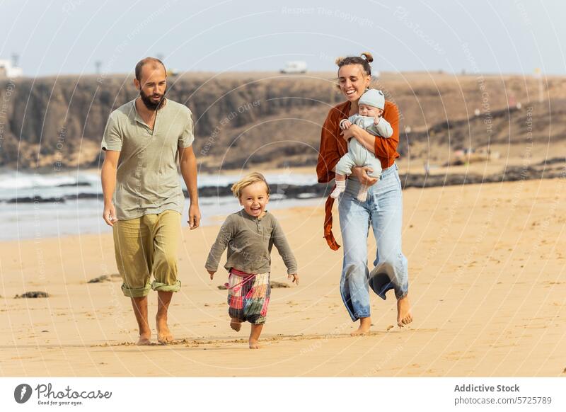 Family joy on a sandy beach stroll family fun walk sea cliffs coastline toddler baby parents smiling outdoor leisure activity casual clothing togetherness