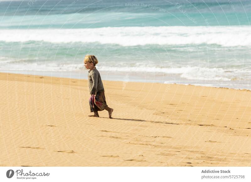 Young boy walking alone on a sandy beach child ocean wave serene sunny day thoughtful innocence exploration water seaside shore coast tranquil peaceful nature