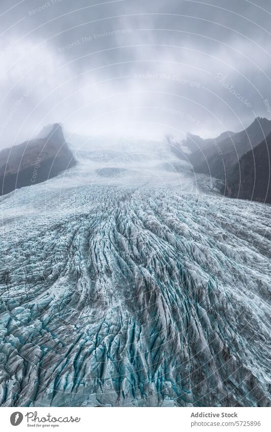 The dramatic textures of Vatnajökull Glacier's surface are highlighted beneath a brooding Icelandic sky, creating a mesmerizing natural tapestry glacier ice