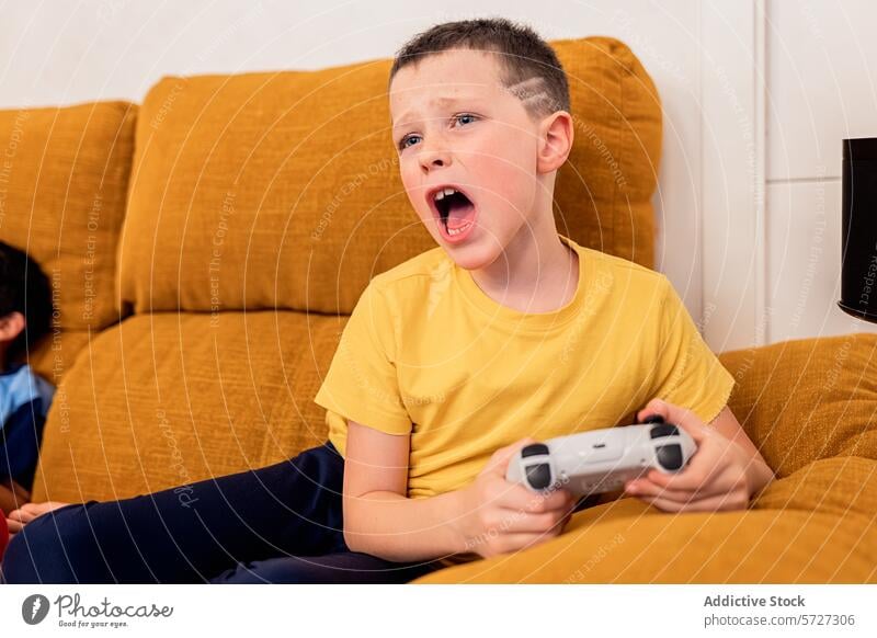 Frustrated young boy losing a video game at home frustration emotion couch living room controller player gaming reaction expressive facial expression defeat
