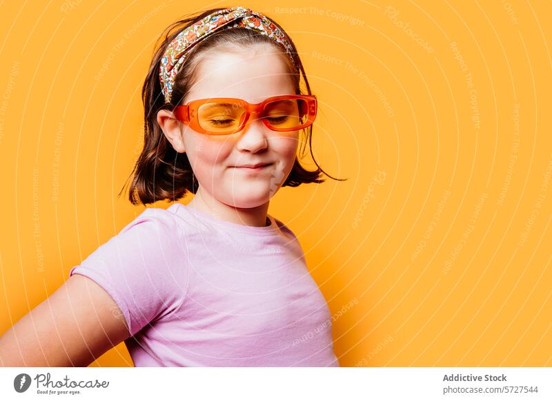 Smiling child with colorful headband and sunglasses girl smile playful trendy orange background cheerful young fashion style kid happiness eyewear portrait fun