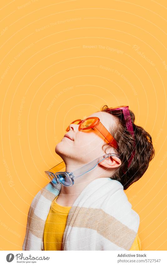 Youthful spirit with colorful sunglasses and headphones child kid boy youth vibrant individual orange background style fashion accessory listen music modern
