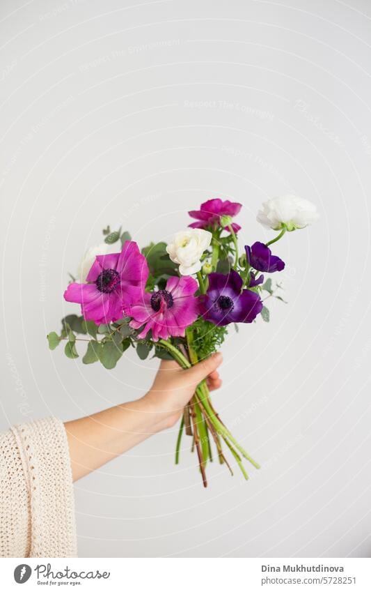 hand of  woman holding bouquet of flowers on white background. I can buy myself flowers. Happy Birthday or Anniversary. floral florist beautiful decoration