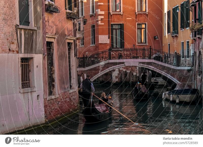 view of a Venetian canal among red brick houses with a gondola sailing venice venetian venice canal red brick building venice buildings water landmark tourism