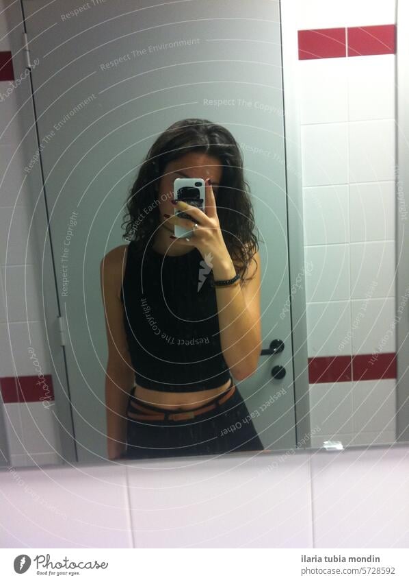 girl with no face and phone wearing black clothes in front of mirror selfie bathroom