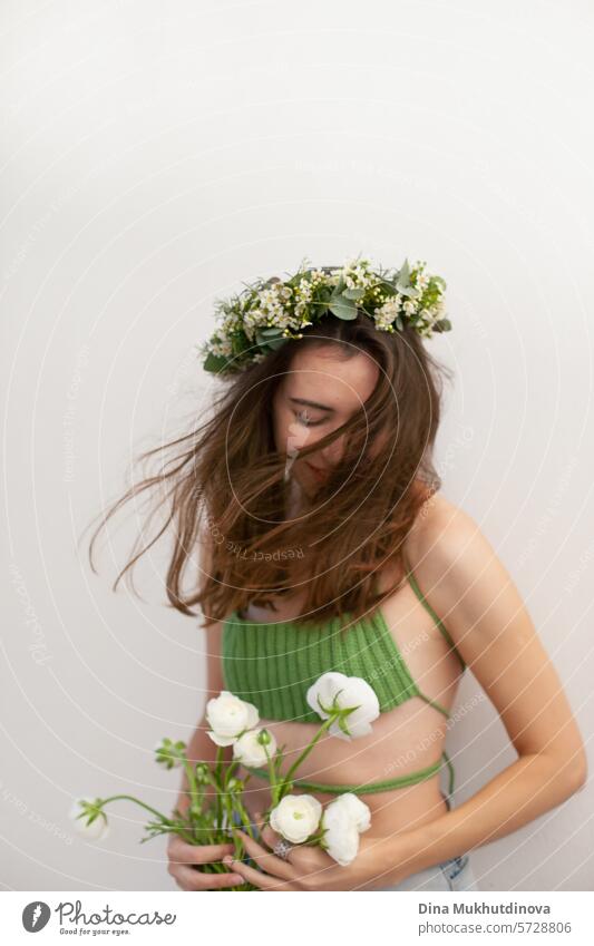 beautiful woman in green crochet handmade top with white flowers and flower headband on white wall minimal background Woman youthful Spring Green Crochet Top