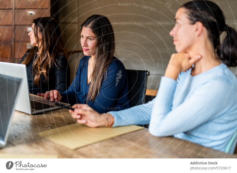 Women in a Business Meeting at a Modern Office business woman women professional meeting office laptop technology working engaged collaboration teamwork female