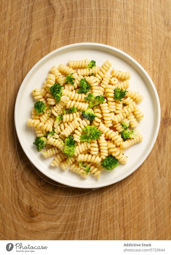 Top view of a delightful dish featuring fusilli pasta mixed with bright green broccoli florets, presented on a white plate top view meal Italian food vegetable