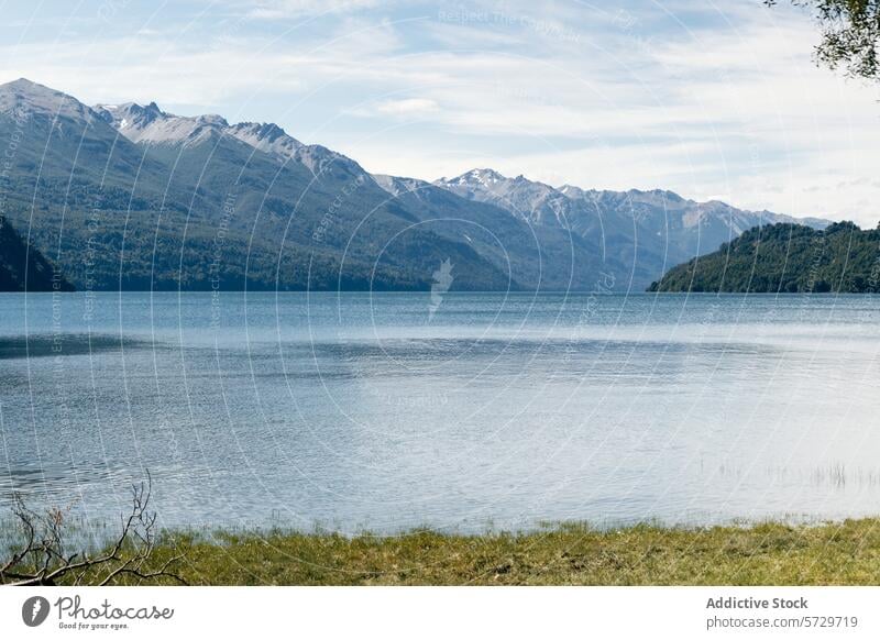 Tranquil waters of a Patagonian lake reflect the surrounding mountain range and lush forests under a clear blue sky tranquil reflection serene Argentina nature