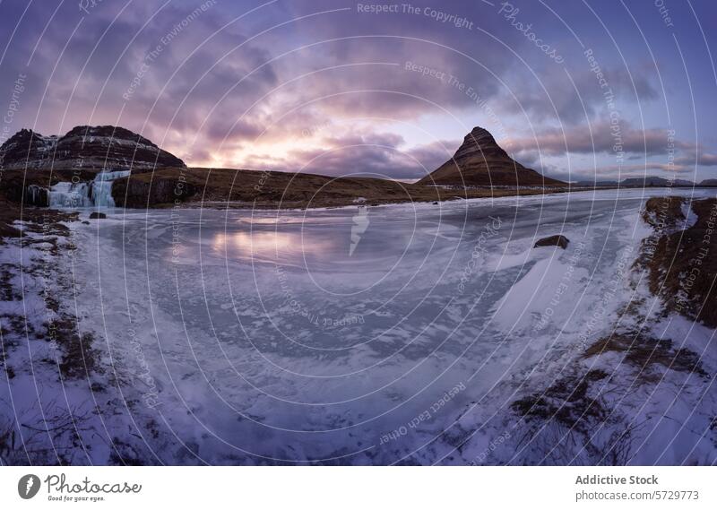 Frozen landscape with iconic mountain at twilight Kirkjufell panoramic frozen river waterfall sky majestic pyramid-shaped distinctive view cascading winter ice