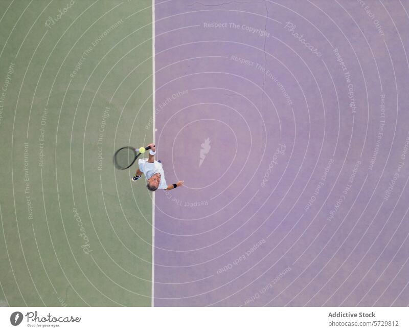 Aerial view of a tennis player serving the ball man aerial sunlit court sport activity outdoor match game action athletic competition fitness serve racket