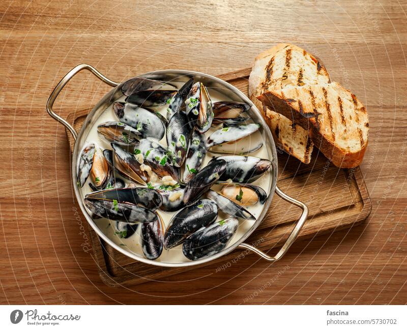 Creamy mussels on wooden background pan creamy seafood sauce dish restaurant cooked delicious meal cuisine gourmet tasty healthy dinner shellfish traditional