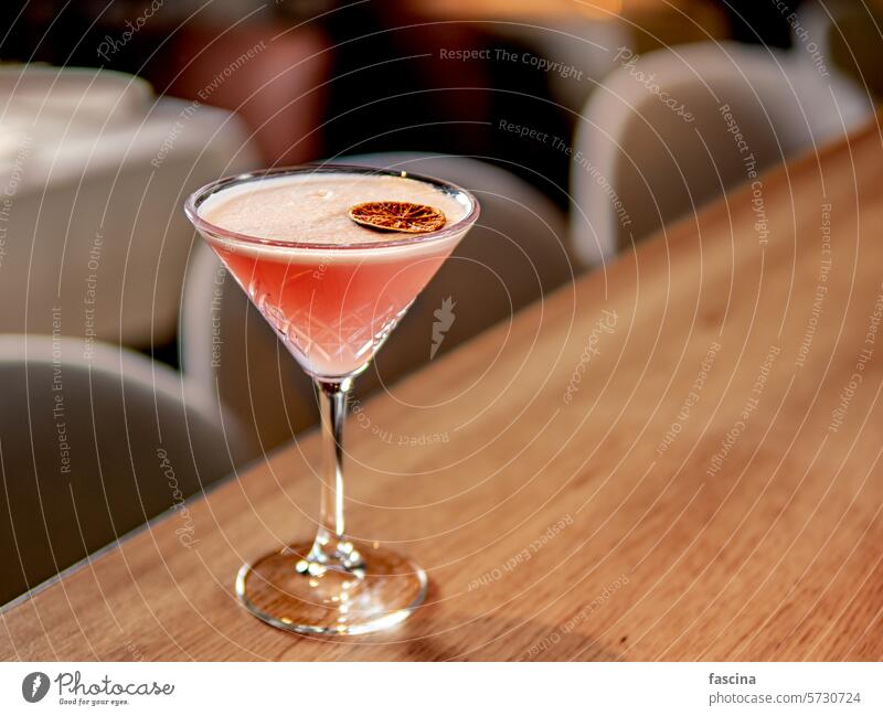 Red pink cocktail with egg white in restaurant gin lichee lychee syrup lychee liqueur protein red martini glass bar counter alcohol decorated drink beverage