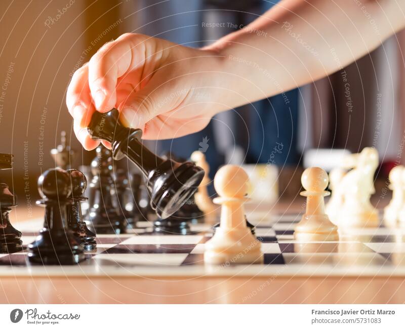 Girl's hand moving chess piece. strategy horizontal conflict battle competition white color black color war contemplation playing game victory intelligence