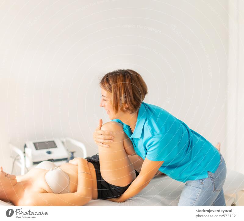 A female physiotherapist performs stretches and massages on her patient's legs and hips clinic rehabilitation health care physiotherapy woman treatment