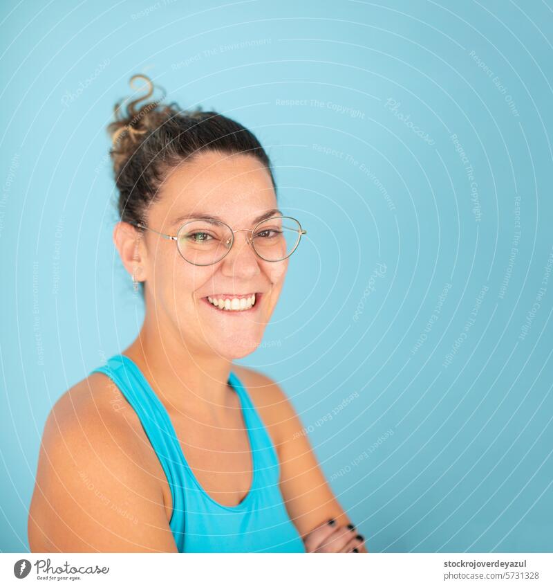 A woman wearing glasses smiles happily and confidently after receiving a manual therapy session at a physiotherapy clinic female portrait young person hair up
