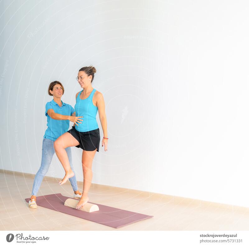 A physiotherapist helps a patient, during a therapeutic Pilates workout session clinic rehabilitation health care physiotherapy exercise fitness coach gym