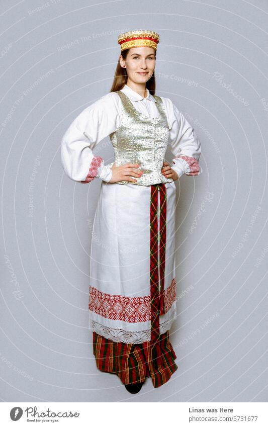 On March 11th, Lithuania celebrates Independence Day. In a studio, a gorgeous brunette girl is dressed in a vintage Lithuanian outfit, radiating happiness. A beautiful woman celebrating a special day for all Lithuanians around the world!