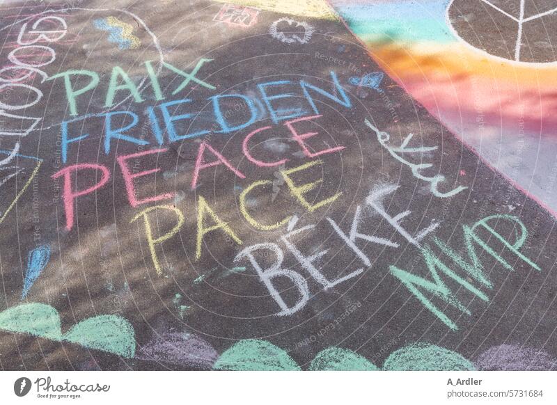 Lettering Peace, Paix, Peace, Pace, Мир painted with colored chalk on asphalt Attachment Sign Friendship Prismatic colors Demonstration Peace Declaration peace