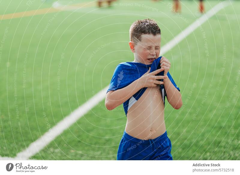 Young boy in discomfort during a soccer game distress injury exhaustion sport field sunny day young player outdoor activity physical pain emotion childhood