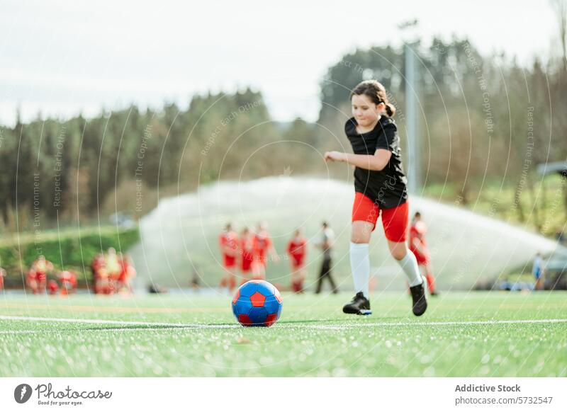 Young soccer player dribbling ball on field girl sport young team background sunny day green grass confidence youth outdoor activity sportswear uniform