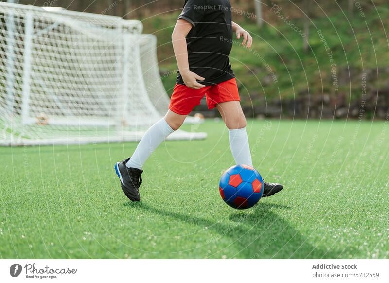 Young player in action on soccer field youth dribble ball green sport football kid game athletic outdoor exercise healthy lifestyle leisure activity skill