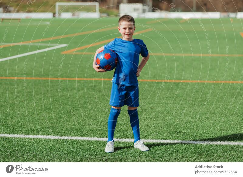 Young soccer player smiling on the field with a ball boy sport young smile confident thumbs-up gear youth football active healthy hobby grass outdoor athletic