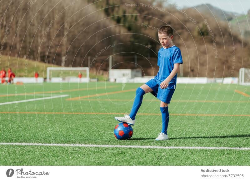 Young soccer player practicing on field young boy sportswear blue soccer field ball foot goalpost background training practice outdoor youth soccer practice