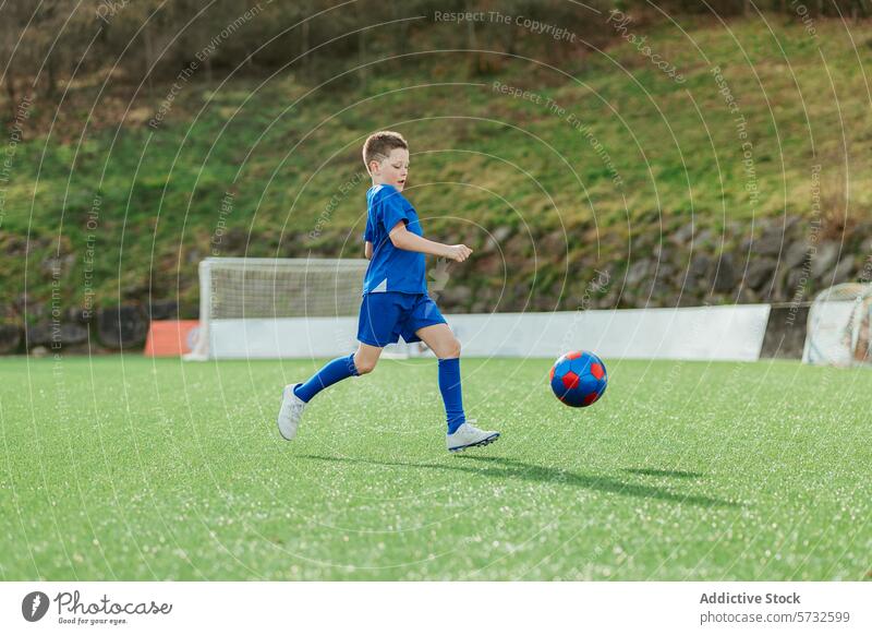 Young boy playing soccer on a green field sport ball kick outdoor blue gear young child activity athletic game youth training soccer field practice leisure