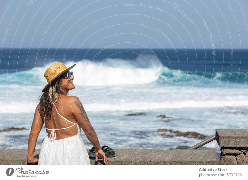 Woman enjoying ocean view on weekend getaway woman relaxation seaside peace freedom back view unrecognizable faceless looking away crashing waves leisure travel