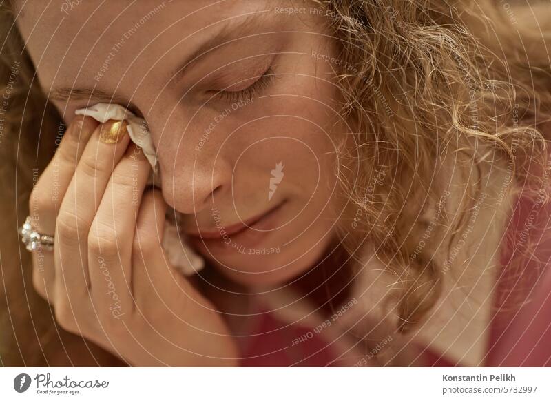 Close up of young woman crying during emotional therapy session and wiping tears with tissue, copy space girl support group mental health meeting hold grief