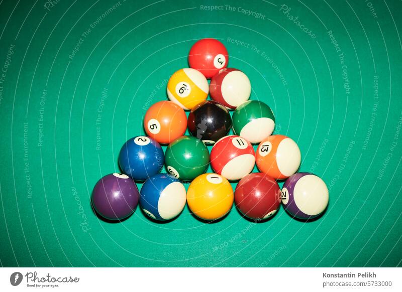 Top view background image ofcolorful billiards ball set in triangle ready for pool game on green table shot with flash, copy space sport top view hobby