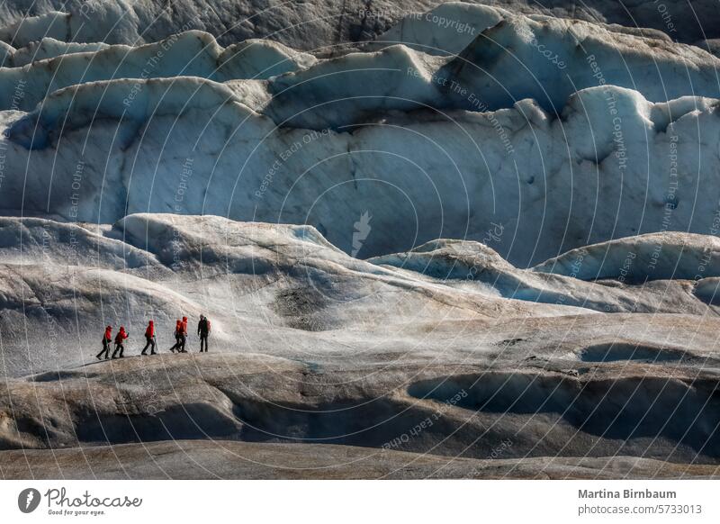 A group of hikrs on a glacier in Alaska, USA alaska landscape sport travel people nature adventure hike extreme ice trek crevasse blue hiking man winter tourism