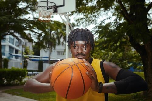 Portrait of positive basketball player training on street court streetball throw portrait guy active sportsman athlete fun goal hands person game outdoor friend