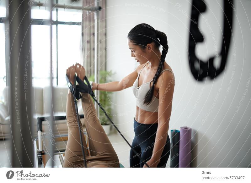 Fitness trainer explains to a customer how to stretch the legs on a machine muscle raise Machinery Coach Sports Equipment Trainer Be suitable Strong Client reha