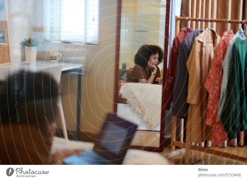 Reflection of a woman lying on a bed and working on a product presentation on a laptop Study Mirror freelancers uh ux User interface Education price Comfortable