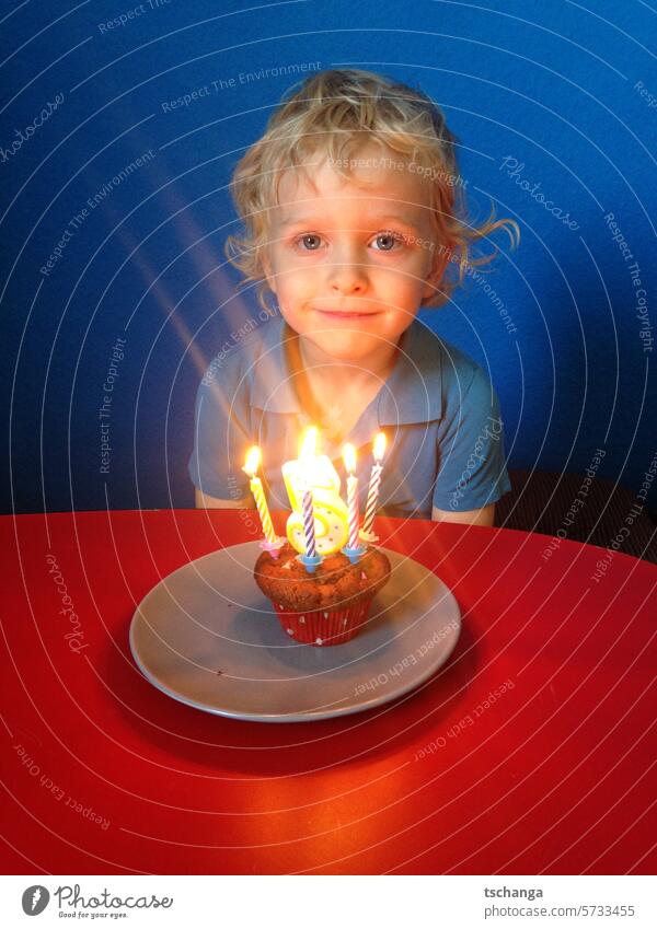 Young birthday 5 at the table with cupcake and candles Boy (child) Blonde portrait Human being Colour photo 5 years Birthday Muffin Smiling Curl hair blue eyes