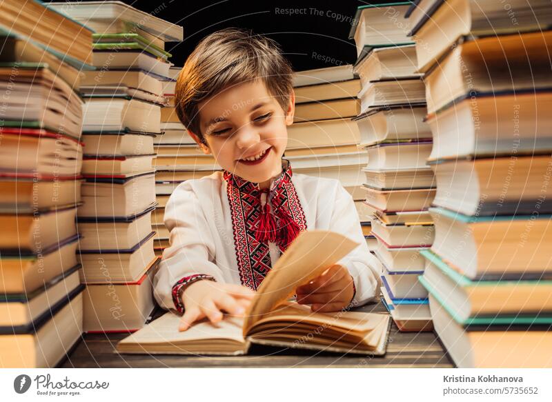 Handsome little ukrainian child flips through book pages in library. Elementary school boy enjoying reading in bookshop or bookstore education study literature