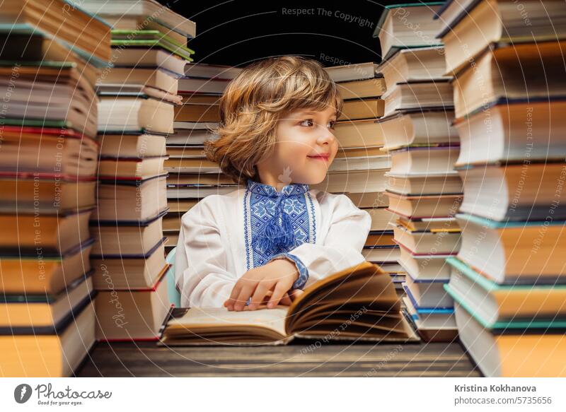 Portrait of handsome little ukrainian child with book in library. Elementary school boy posing in bookshop or bookstore. education study literature read student