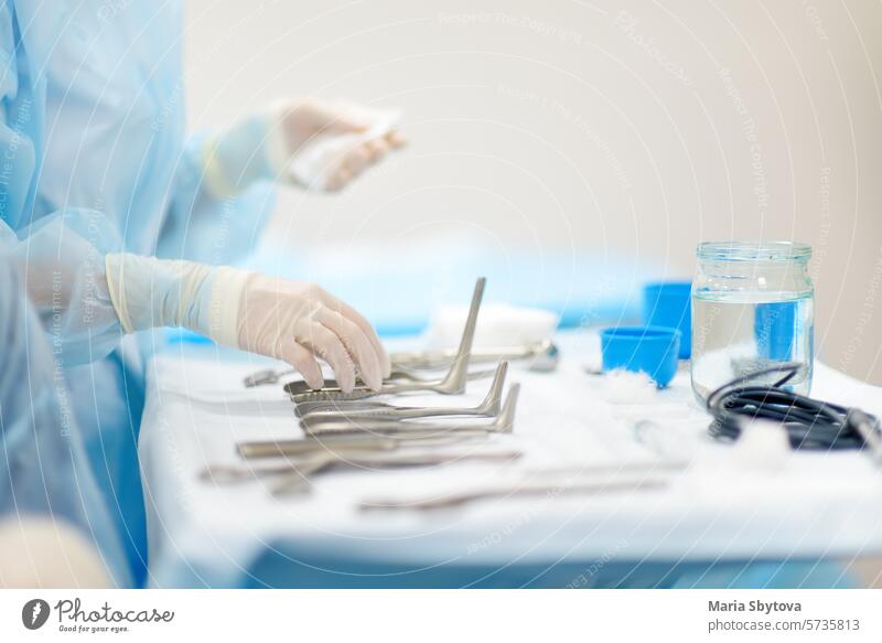 A nurse hands surgical instruments to a doctor during maxillofacial surgery operation. Sterile medical tools sterile surgeon room assistant gown hospital
