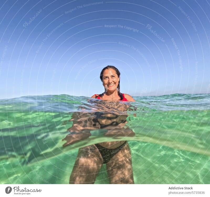 Woman smiling in the ocean, split view above and underwater woman smile summer sea happy swimming float clear leisure vacation travel adventure outdoors nature
