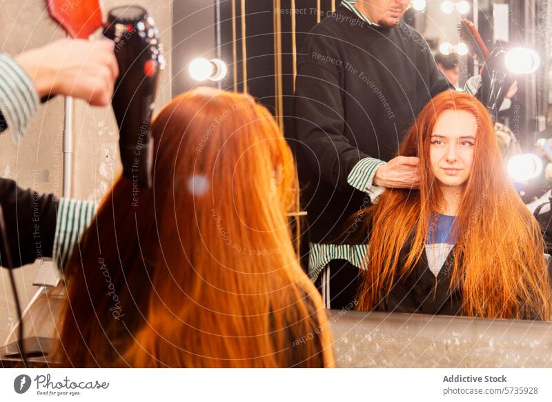 Hairstylist working on client's hair in salon hairstylist mirror blow dryer young woman red hair long hair hairdressing professional grooming beauty hairstyle
