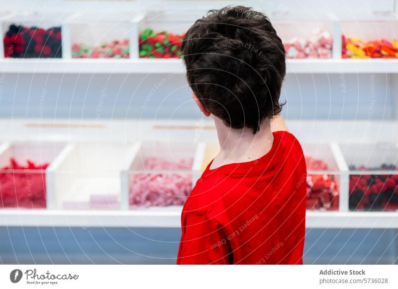 Young customer choosing candies at a candy shop person red shirt behind colorful display choice variety confectionery sweet retail snack dessert food treat