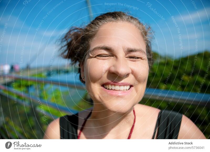 A radiant woman beams with a closed-eye smile, basking in the sunshine at the Langkawi Sky Bridge in Malaysia sky bridge happy bright day travel joy vacation