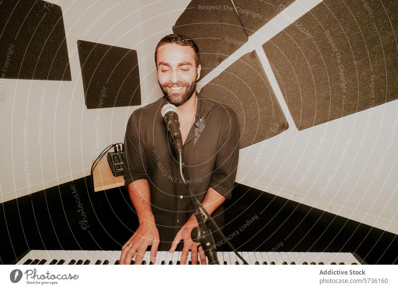 Smiling male musician playing piano and singing man microphone joyful smiling keyboard performance entertainment studio musical instrument artist vocalist