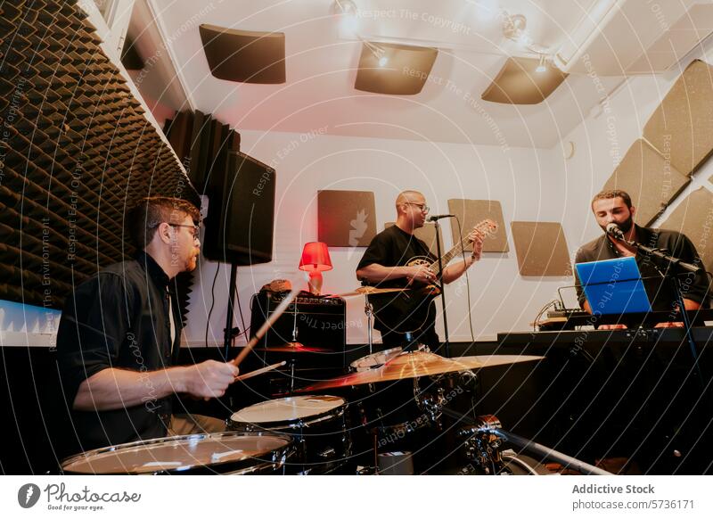 Men performing in a home music studio setting band men male home studio drummer guitarist vocalist acoustic panel performance session musician microphone