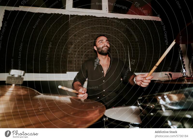 Passionate male drummer playing in a dark studio man drums drumstick music musician performance instrument percussion band bearded focus intense artistic