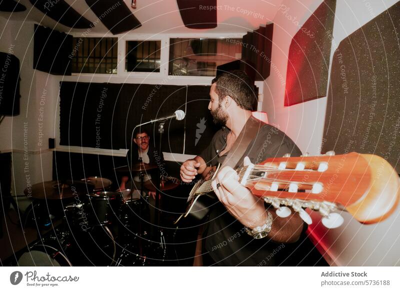 Male musicians performing in a cozy venue setting band male men guitarist acoustic looking away drummer drums live entertainment instrument performance studio